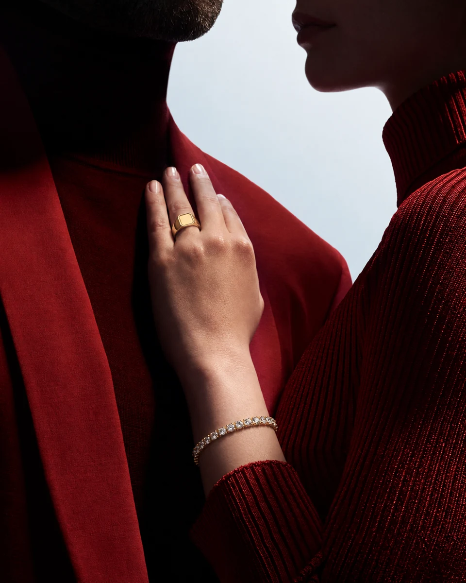 Hand mit Ring und Armband auf rotem Samt