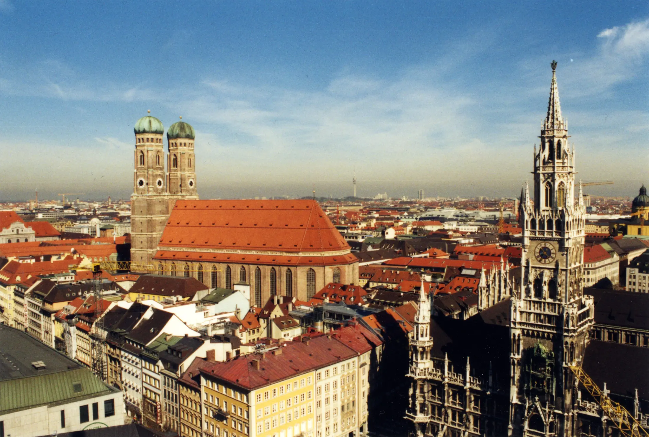 Münchner Frauenkirche und Neues Rathaus über den Dächern der Altstadt bei Sonne
