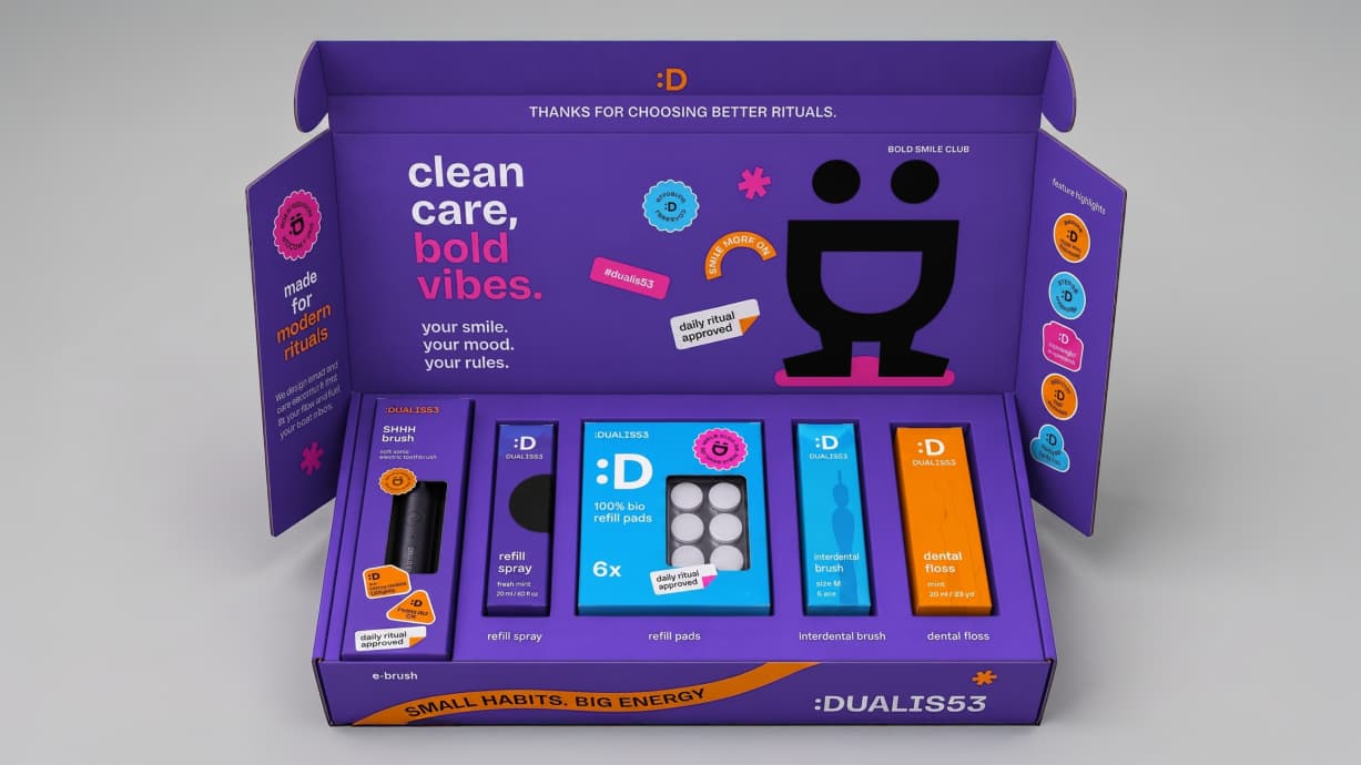 Geöffnete Box von Dualis53 mit Produkten, Figur und Botschaften im Deckel